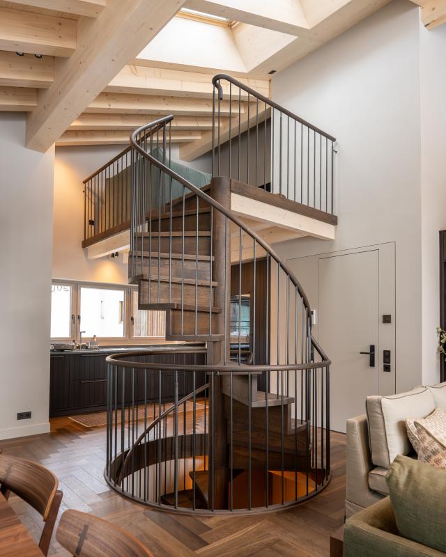 Die Treppen wurden vollständig aus hochwertigem Eichenholz gefertigt und mit einem braunen Öl veredelt. Das Geländer zeichnet sich durch filigrane Sprossen aus Schwarzstahl aus und verleiht dem Design eine elegante Note.