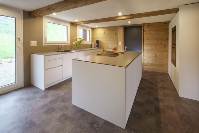 Kochinsel und Hochschrankblock in Weiss mit farblich passenden Griffmulden und Chromstahlabdeckung